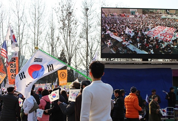 ▲ 4일 대통령 탄핵 기각을 위한 국민총궐기 운동본부가 주최한 태극기집회에 참석해 태극기를 흔들고 있는 30대 조모씨. ⓒ뉴데일리 강유화 기자