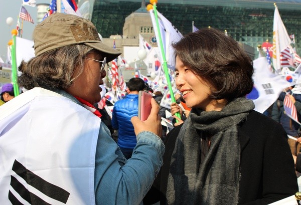 ▲ 4일 대통령 탄핵 기각을 위한 국민총궐기 운동본부가 주최한 태극기집회에 참석한 시민과 전희경 자유한국당 의원이 이야기를 나누고 있다. ⓒ뉴데일리 강유화