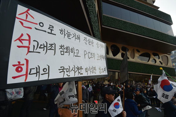 ▲ 4일 오후 서울 도심일대에서 열린 대통령 탄핵기각을 위해 16차 태극기집회에 참여한 한 시민이, JTBC의 태블릿PC 조작보도 의혹을 꼬집는 피켓을 들고 있다. ⓒ 뉴데일리 이종현 기자