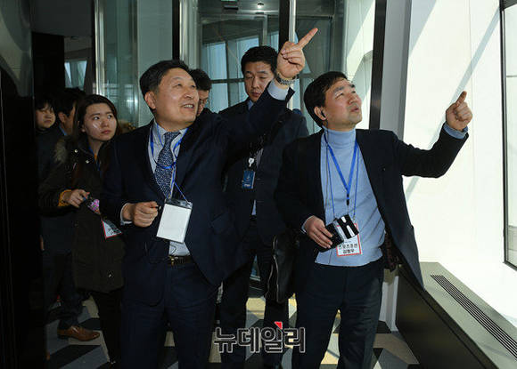 ▲ 박동기 롯데월드 대표이사가 서울스카이 전망대에서 하늘을 가리키며 웃고 있다.(중앙 왼쪽). ⓒ정상윤 기자