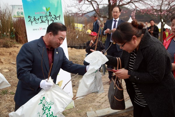 ▲ 지난해 열린 묘목 축제장에서 김영만 군수가 축제장을 찾은 방문객에게 묘목을 나눠주고 있다.ⓒ옥천군