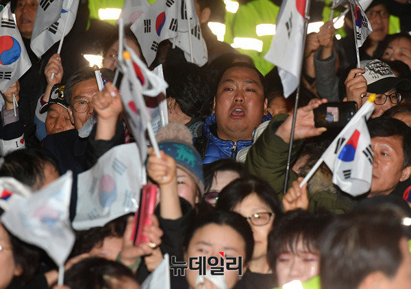 ▲ 지난 12일 박근혜 전 대통령이 삼성동 사저로 복귀한다는 소식을 접한 지지자들이 태극기를 흔들고 있다. ⓒ뉴데일리 정상윤 기자