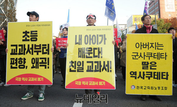 ▲ 국정교과서 채택 취소를 압박하며 시위를 벌이고 시민들이, 전교조 등 명의의 손 팻말을 들고 있다. ⓒ 뉴데일리DB
