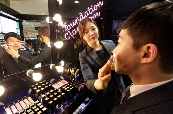 ▲ 에스티로더 화장품 매장에서 남성 고객이 메이크업을 받는 모습ⓒ롯데백화점