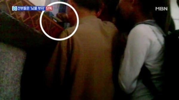 ▲ 최근 북한 당국이 개인 여행객들과 화교들에게 중국 여행증 발급을 조건으로 내세워 일정 품목을 국가에 바치도록 강요하고 있는 것으로 알려졌다. 사진은 북한 주민들이 여행증 발급을 받기 위해 간부들에게 뇌물을 건넨다는 내용의 'MBN' 보도 일부.ⓒ'MBN' 보도영상 캡쳐