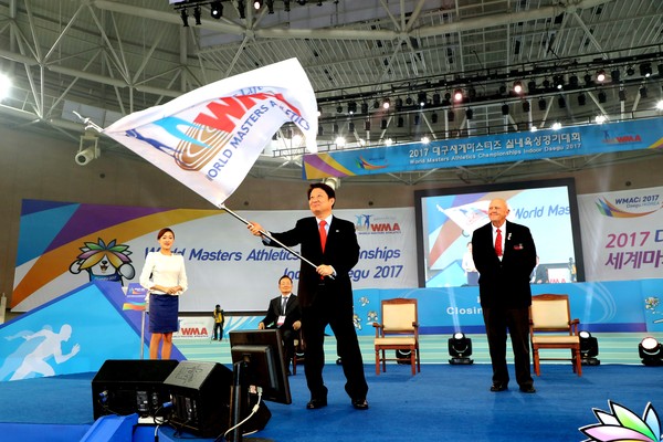 ▲ 전 세계 생활체육 매니아들의 무대인 ‘2017대구세계마스터즈실내육상경기대회’가 25일 폐회를 끝으로 대단원의 막을 내렸다. 권영진 대구시장이 대회기를 흔들고 있다.ⓒ대구시 제공