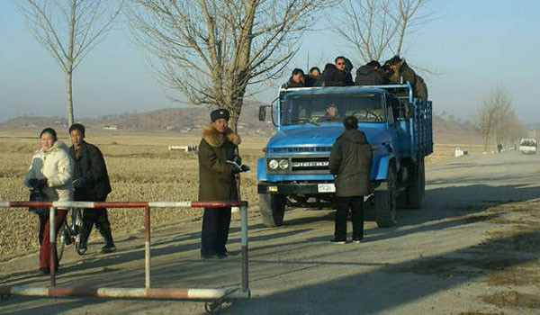 ▲ 북한의 한 초소에서 주민들이 탄 트럭을 검문하는 북한 인민보안원들. ⓒ뉴포커스 北관련보도 화면캡쳐