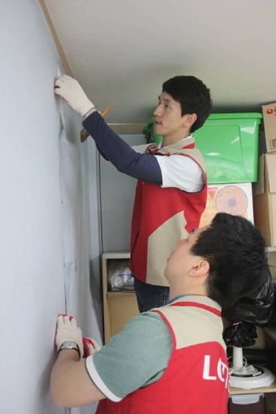 ▲ 샤롯데 봉사단원들이 아동센터 내부 도배작업을 하고 있다. ⓒ 롯데건설