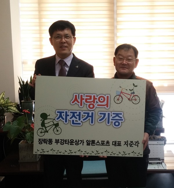 ▲ 제천 알톤스포츠 지준각 대표(오른쪽)가 학생들에게 전달해 달라며 조완형 교동 동장에게 자전거를 기탁하고 있다.ⓒ교동주민센터