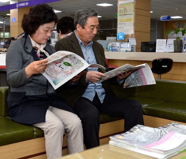 ▲ 제천시청 민원실을 방문한 어르신들이 대활자본 소식지를 보고 있다.ⓒ제천시