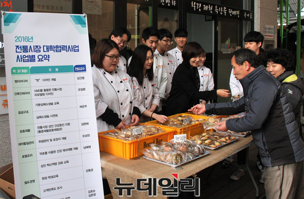 ▲ 대원대 호텔조리계열 제과제빵 동아리 학생들과 남혜영 지도교수가 제천역전한마음시장에서 레시피 교육을 통해 만들어진 제과제빵을 상인들에게 선보이고 있다.ⓒ목성균 기자