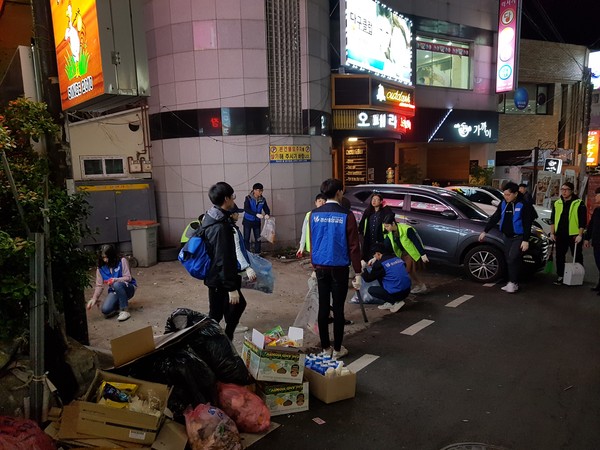 ▲ 경산월드휴먼브리지가 지난 7일 영남대학교 주변 오렌지타운 거리의 쓰레기 수거 봉사활동을 실시했다.ⓒ경산시