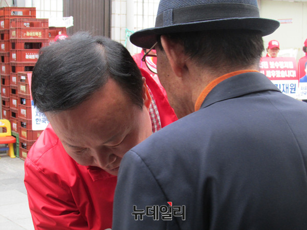 ▲ 자유한국당 김재원 후보가 9일 경북 청송시장에서 한 노인 유권자와 손을 꼭 맞잡은채 몸을 굽혀 귀엣말을 듣고 있다. ⓒ청송(경북)=뉴데일리 정도원 기자