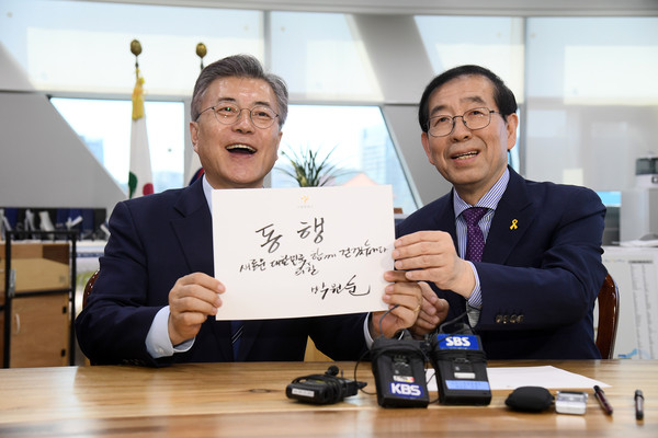 ▲ 박원순 서울시장이 시청을 방문한 문재인 더불어민주당 대선후보에게 '동행 새로운 대한민국의 길 함께 걷겠습니다'라는 문구를 적어 선물했다. ⓒ서울시 제공