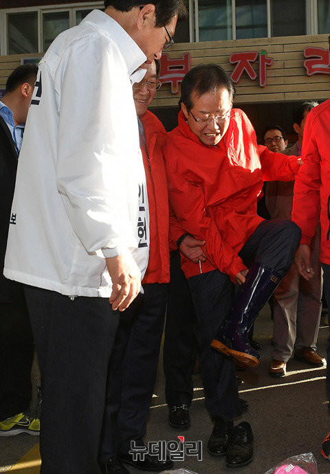 ▲ 자유한국당 홍준표 후보가 괴산의 전통시장을 방문해 장화를 신어보고 있다. 이에 대해 김명연 수석대변인은 