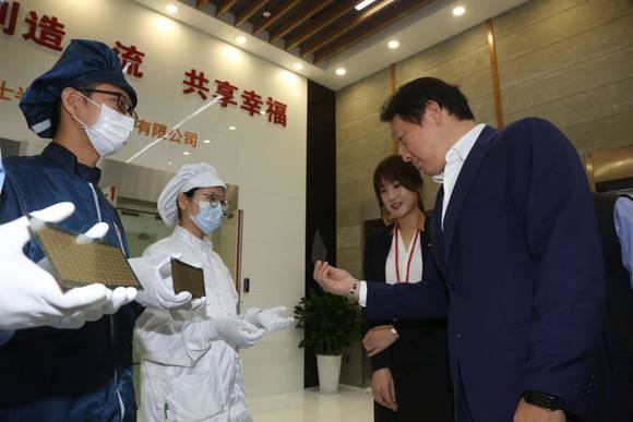 ▲ 최태원 SK그룹 회장(오른쪽)이 2016년 9월 SK하이닉스 충칭 공장을 방문해 제품을 살펴보고 있다.ⓒSK