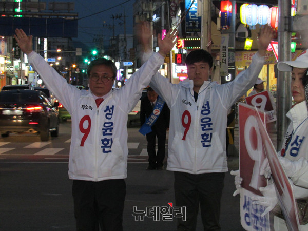 ▲ 무소속 성윤환 후보가 11일 저녁 상주 서문사거리에서 아들과 함께 지나가는 차량을 향해 손을 흔들며 퇴근 인사를 하고 있다. ⓒ상주(경북)=뉴데일리 정도원 기자