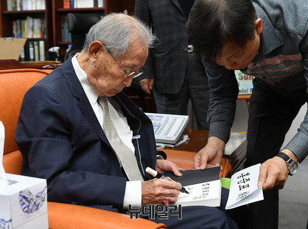 ▲ 홍준표 후보에 선물할 책에 친필서명 하고 있는 백선엽 전 장군. 그는 떨리는 손을 붙들기 위해 이를 악물었다. ⓒ뉴데일리 정상윤 기자