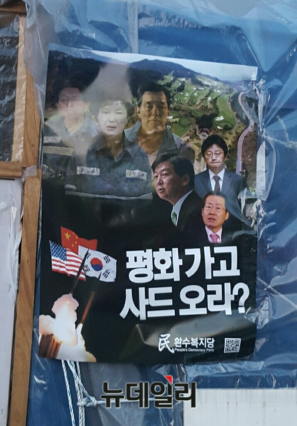 ▲ 15일 서울 광화문광장에서 세월호 3주기 추모식이 열린 가운데 ‘환수복지당’ 당원들이 특정 대선후보의 얼굴이 담긴 사드반대 포스터를 광장에 붙이다 선거법 위반 혐의로 경찰에 연행됐다. ⓒ 뉴데일리 임혜진 기자
