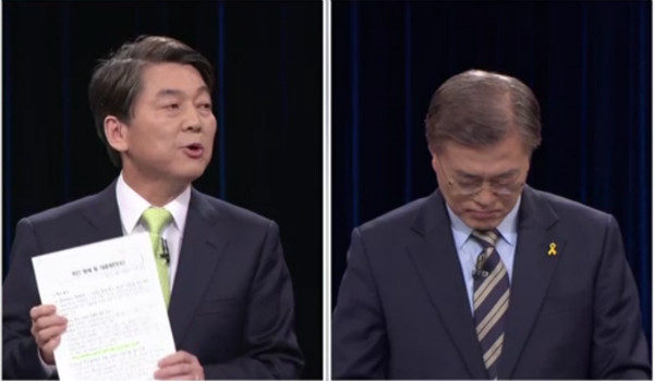 ▲ 국민의당 안철수 후보가 23일 열린 중앙선거방송토론위 주관 대선후보 토론회에서 민주당의 이른바 네거티브 문건 사본을 들고나와 추궁하자, 더불어민주당 문재인 후보가 고개를 숙여 이를 외면하고 있다. ⓒYTN 방송화면 갈무리