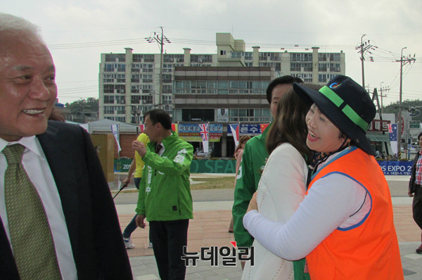 ▲ 26일 오후 전남 완도 국제해조류박람회장에 국민의당 김한길 전 의원 일행이 들어서자, 한 자원봉사자가 최명길 여사에게로 달려가 덥썩 끌어안고 있다. 사진 왼쪽은 이를 보며 웃는 김한길 전 의원. ⓒ완도(전남)=뉴데일리 정도원 기자