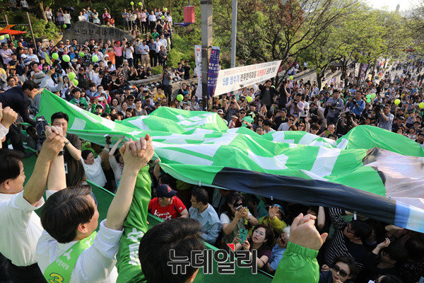 ▲ 국민의당 안철수 후보와 정동영 선대위원장 등이 손을 맞잡고 있는 가운데, 3일 전주한옥마을에서 열린 집중유세에 몰린 1만 청중 위로 현수막이 펼쳐지고 있다. ⓒ전주(전북)=뉴데일리 이종현 기자
