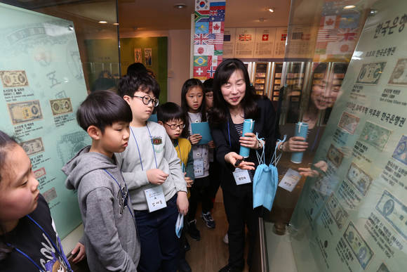 ▲ 신한은행의 한국금융사박물관에서 화폐 전시를 둘러보는 어린이 방문객 모습.ⓒ신한은행