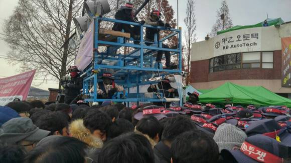 ▲ 지난해 11월 갑을오토텍 정문에서 노조원들이 붉은 머리띠를 두른 모자와 복면을 쓰고 관리직 출근을 저지하는 모습.ⓒ갑을오토텍