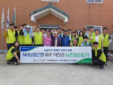 ▲ 김연학 HR·업무지원부문 및 신탁본부 부행장이 직원 30여명과 11일 경기도 파주시 덕천리 마을에서 농촌 일손돕기를 실시한 뒤 기념촬영을 하고 있다. ⓒ 농협은행