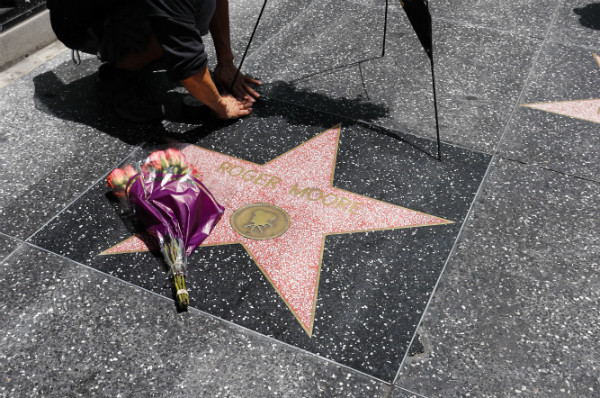 ▲ 영국 기사작 로저 무어 경의 타계 소식이 알려진 23일(현지시각) 미국 할리우드 명예의 거리에 마련된 경의 석판 위에 추도의 꽃송이가 올려져 있다. ⓒ뉴시스 사진DB