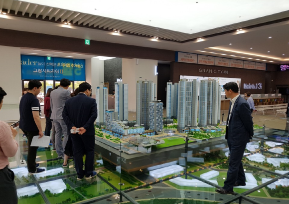 ▲ 경기 안산시 사동 고잔신도시에 마련된 그랑시티자이2차 견본주택 내 모형도를 둘러보고 있는 취재진과 GS건설 관계자들 모습. = 김백선 기자