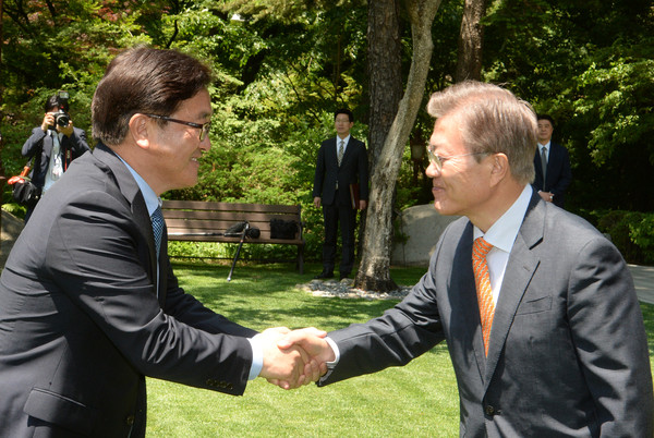 ▲ 우원식 민주당 원내대표가 문재인 대통령에게 두손 악수를 하는 모습. ⓒ뉴시스