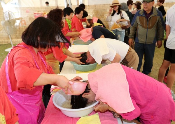 ▲ 지난 28일 유네스코 인류무형문화유산인 강릉단오제가 열리고 있는 강릉시 남대천 단오장 체험촌에서 관람객들이 창포물에 머리를 감고 있다.ⓒ연합뉴스