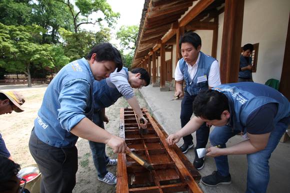 ▲ 포스코 국내외 임직원들이 봉사 특별주간인 '2017 포스코 글로벌 볼런티어 위크'를 맞아 성균관 명륜당 창문과 문짝의 낡은 창호지를 교체하고 있다.ⓒ포스코