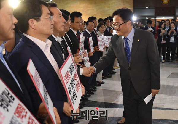 ▲ 자유한국당 의원들이 31일 이낙연 총리 후보자 자진 사퇴를 요구하며 시위를 벌이는 모습이다. 심각한 표정의 자유한국당 의원에게 집권당인 더불어민주당 우원식 원내대표가 싱긋 웃으며 자유한국당 의원에 악수를 건네고 있다. ⓒ뉴데일리 이종현 기자