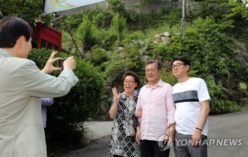 ▲ 주영훈 경호실장이 경남 양산 대통령 사저를 방문한 가족과 대통령의 기념촬영을 하고 있다. ⓒ연합뉴스