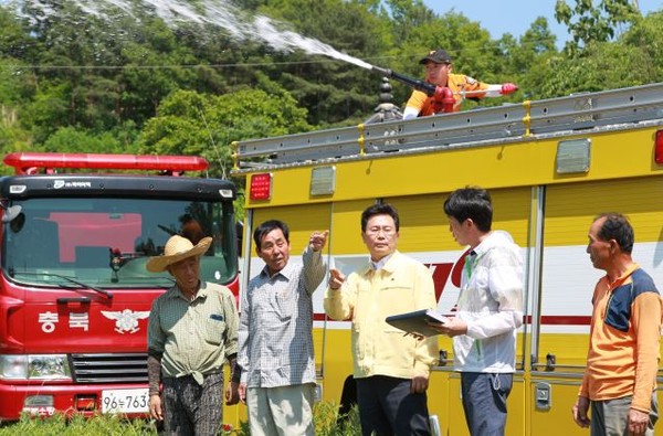 ▲ 고규창 충북 행정부지사가 2일 가뭄이 극심한 옥천과 영동 지역을 방문해 현장을 점검하는 가운데 소방대원이 급수지원을 하고 있다.ⓒ충북도