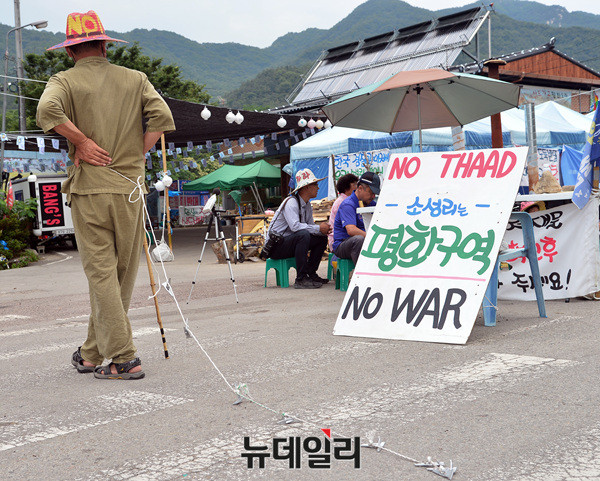 ▲ 성주골프장 입구 도로를 점거한 한 소성리 주민이 허리에 쇠침이 박힌 줄을 끌고 다니고 있다 ⓒ 뉴데일리 공준표