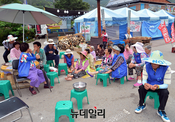 ▲ 성주골프장 입구 도로를 점거한 한 소성리 주민이 허리에 쇠침이 박힌 줄을 끌고 다니고 있다 ⓒ 뉴데일리 공준표