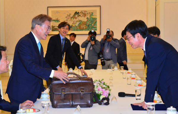 ▲ 문재인 대통령이 13일 김상조 공정거래위원장 임명 강행을 결정하고 임명장을 수여한 직후, 김상조 위원장으로부터 가방을 전달받아 살펴보고 있다. ⓒ뉴시스 사진DB