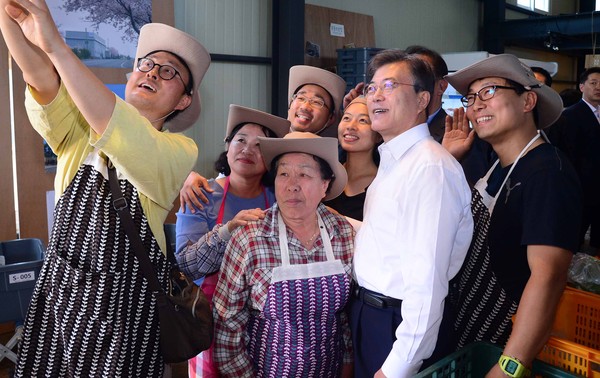 ▲ 문재인 대통령이 16일 제주 서귀포시에 위치한 무릉외갓집을 찾아 직원들과 기념촬영을 하고 있다. ⓒ뉴시스 사진DB