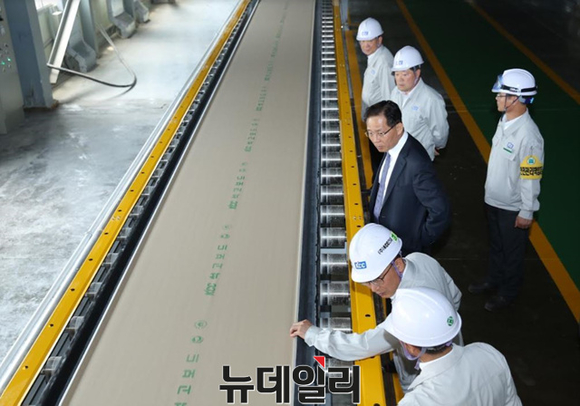▲ KCC 정몽익 사장(사진 가운데 양복착용)이 20일 증설된 대죽공장 석고보드 3호기 생산라인을 방문해 둘러보고 있다.ⓒKCC