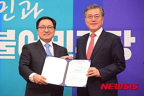 ▲ 유영민 미래창조과학부 장관 후보자가 지난해 1월 더불어민주당 입당식에서 당시 문재인 대표에게 입당서를 제출하는 모습ⓒ뉴시스