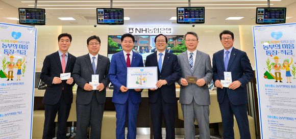 ▲ 농협은행은 지난 4월 20일 ‘NH農心-농부의마음 통장·적금’을 출시했다. 이날 이경섭 농협은행장(왼쪽 두 번째부터), 김병원 농협중앙회장, 김용환 농협금융지주 회장, 이창현 농협은행 부행장 등 농협 임원들도 상품에 가입하며 농업경제 활성화에 힘을 보탰다.ⓒNH농협금융지주