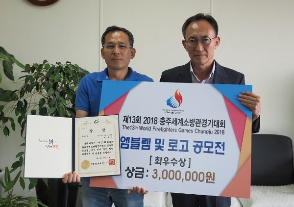 ▲ 충북소방본부가 5일 제13회 ‘2018 충주세계소방관경기대회’ 공식 엠블렘및 로고 공모전에서 최우수수상을 수상한 이용기씨에게 상장을 전달했다.ⓒ충북도