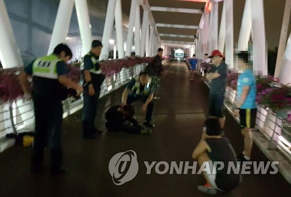 ▲ 5일 밤 부산의 한 다리에서 뛰어내리려는 자살 기도자를 다른 시민과 함께 구조한 탤런트 한정국(빨간 모자).  ⓒ 부산 사상경찰서 제공=연합뉴스