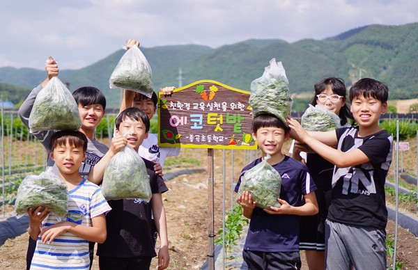 ▲ 충북 보은군 종곡초등학교 텃밭에서 아이들이 직접키운 채소를 들어보이고 있다.ⓒ충북교육청