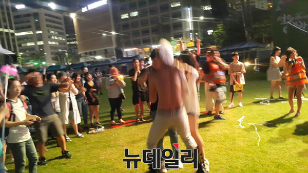 14일 밤 퀴어축제에 참여한 한 남성이 상의를 벗고 여성과 춤을 추고 있다. ⓒ뉴데일리 박진형 기자