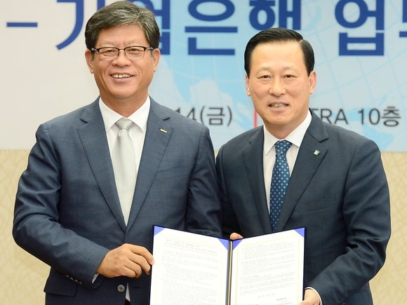 ▲ 14일 김도진 기업은행장(오른쪽)과 김재홍 코트라 사장이 업무 협약을 마치고 기념촬영을 하고 있다.ⓒIBK기업은행