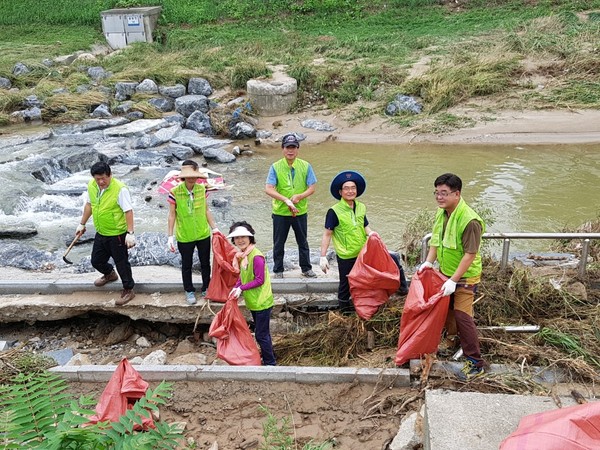 ▲ 국민의당 청원구 지역위원회 봉사단 소속 20여명이 18일 폭우로 피해가 발생한 율량천 인근에서 봉사활동을 펼쳤다.ⓒ국민의당 충북도당